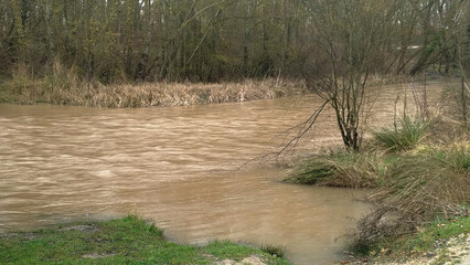Crecida de río por abundantes lluvias un día lluvioso en Burgos, España