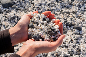 White popcorn-shaped stones in a woman's hand forming a heart