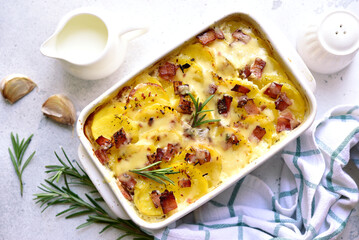 Potato gratin with bacon - traditional dish of french cuisine. Vegetables baked in milk sauce with cheese.
