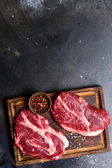 Raw organic marbled beef steak with ingredients for cooking . Top view with copy space.
