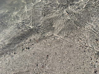 soft water ripples over pebble sand. minimal abstract pattern. natural texture. liquid pattern. meditative feel. abstract background. meditation backdrop. wellness