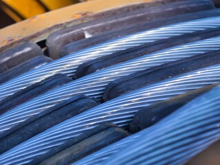 A large wooden spool of high-voltage electric wires is located on the road
