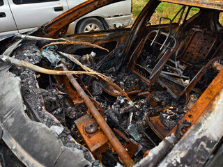 Charred remnants of a vehicle interior left behind after a devastating fire incident