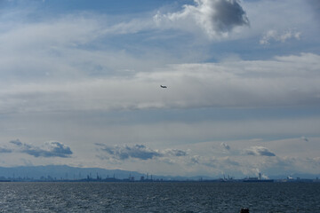 東京湾と澄んだ青空を飛ぶ飛行機