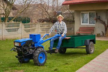 a young farmer is sitting on a two-wheeled tractor, a man is sitting on a brand new tractor in the...