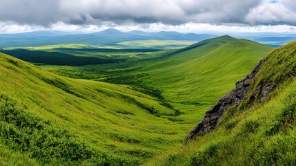Naklejka premium Lush Green Mountain Valley Landscape under Cloudy Sky
