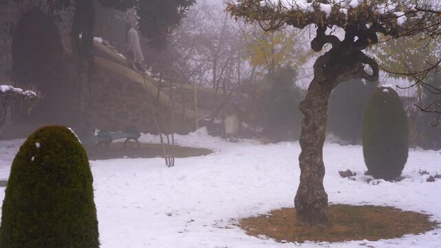 Panning shot of the snow and fog covered grounds with shaped trees at the Pari Mahal castle fort in Srinagar Kashmir a popular tourist spot