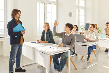 Teacher and students group in class during lesson, working and study in college trainee interns sitting focused studying online, young people learning language, involved in answering questions