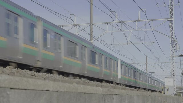 横浜・東京方面へ住宅街を快走する東海道線のE231系普通列車