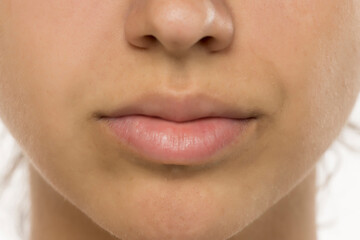 Obraz premium Close-up of natural, makeup-free lips and skin. Detailed view showing texture, subtle freckles, and soft lip color. Skincare and beauty concept