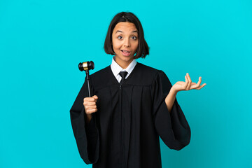 Judge over isolated blue background with shocked facial expression