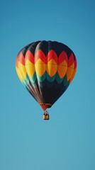 Obraz premium Vibrant Hot Air Balloon Floating in Clear Blue Sky