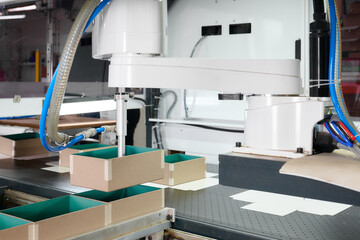 Robotic arms sorting decorative boxes on an efficient conveyor system in a modern box manufacturing facility