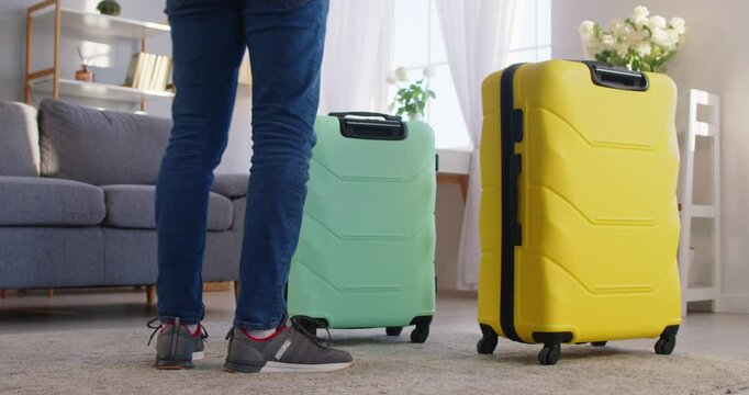 Traveller tourist arriving with two wheel suitcase, renting apartment entering flat after summer trip holiday, man rolling luggage bag for vacation travel, destination, student moving hotel or hostel
