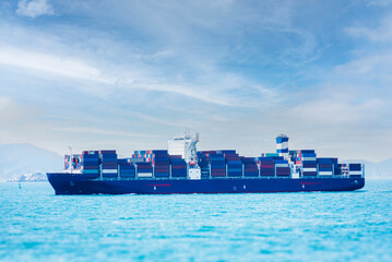 Large cargo container ship at sea, she is fully loaded with colorful containers.