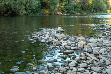 The river bank is partially covered with large stones with beautiful colors in the spring.
