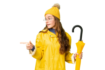 Teenager girl with rainproof coat and umbrella over isolated chroma key background pointing finger to the side and presenting a product
