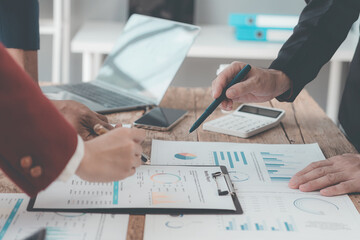 Meeting room for business presentations or seminars Close-up of hand pointing at charts and graphs on table and data analysis Collaborative discussion about statistics Business team working on analysi