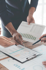 Meeting room for business presentations or seminars Close-up of hand pointing at charts and graphs on table and data analysis Collaborative discussion about statistics Business team working on analysi