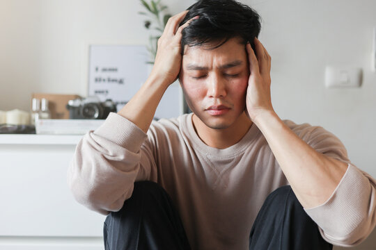 close up young asian man hand on head with stress feeling or headache  in bedroom for depress and worry concept