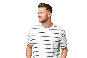 Young blonde caucasian man over isolated background looking to the side and smiling