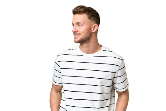 Fototapeta Young blonde caucasian man over isolated background looking to the side and smiling