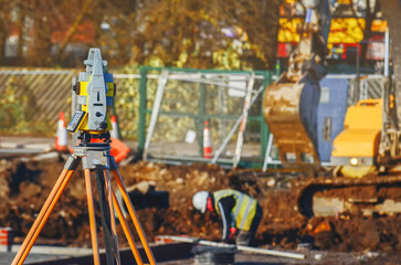 Construction site showing equipment and workers engaged in earthmoving activities during a sunny day at a new development location