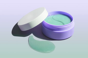 Cosmetic product purple glitter lavender eye patches in plastic jar. Gradient background.