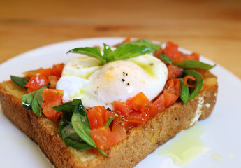 Closeup of Mouthwatering Fresh Tomato and Basil Toast Topped with Poached Egg