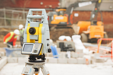 Fototapeta premium Construction team utilizes surveying equipment for precise measurements on worksite