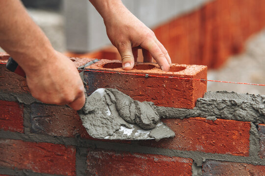 Close-up of hands of bricklayer Constructing brick wall with precision and skill