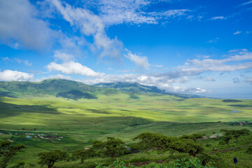 Überblick über die Graslandschaft in der Nähe des Ngorongoro Krater am Rande der Serengeti in Tansania Afrika mit einem kleinen Dorf der Einheimischen 