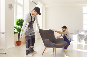 Plastic furniture covers for moving, delivery service, male movers loading, unloading and setting...