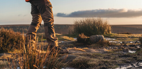 Hiker enjoying  stunning sunset view over rugged terrain in the countryside during  tranquil evening walk in nature