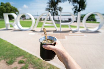 Persona tomando mate frente al cartel turístico de la ciudad de Rosario, en Argentina. Fotografía...