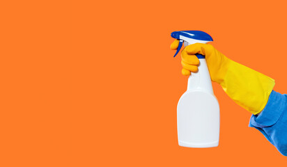 Cleaning supplies in hand for effective household cleaning tasks with bright orange background