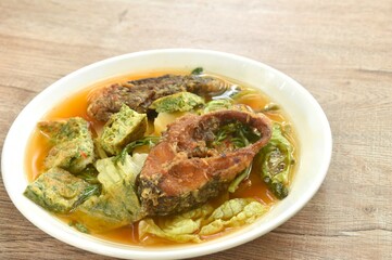 fried snake head fish and egg stuffed climbing wattle in spicy sour soup on plate
