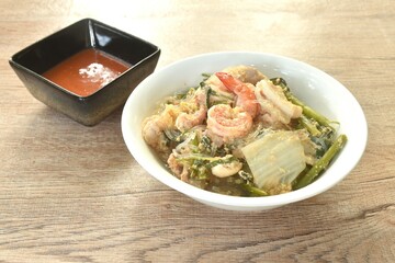 boiled sukiyaki seafood chicken and pork meat couple crispy pickled squid and shrimp with vegetable in soup on bowl dipping sauce