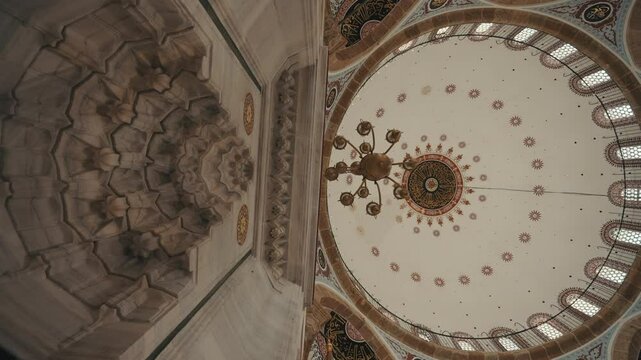 Starting from the detailed decorations of the mihrab niche of the Pertev Mehmet Pasha Mosque, the camera opens up and sees the dome of the mosque, the patterns inside the dome, and the windows.