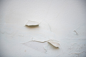Peeling paint on textured wall creates interesting visual contrast