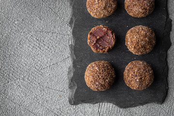 Artisan chocolate truffle candies with berry and fruit filling on dark background, handmade or handcrafted bonbons, chocolatier or confectionary concept. Horizontal banner, copy space