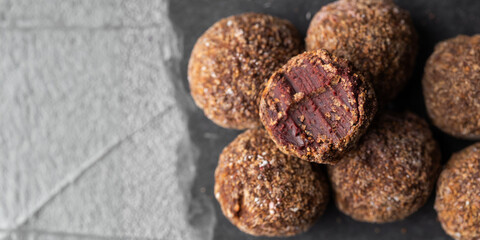 Artisan chocolate truffle candies with berry and fruit filling on dark background, handmade or handcrafted bonbons, chocolatier or confectionary concept. Horizontal banner, copy space