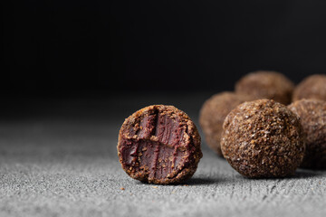 Artisan chocolate truffle candies with berry and fruit filling on dark background, handmade or handcrafted bonbons, chocolatier or confectionary concept. Horizontal banner, copy space