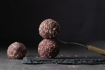 Healthy artisan chocolate truffle candies with berry and fruit filling on dark background from confectionary. Handmade or handcrafted bonbons, chocolatier concept. Horizontal banner, copy space
