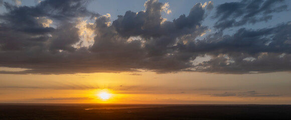 Stunning sunset over a vast landscape, with vibrant colors and dramatic clouds creating a serene atmosphere, ideal for nature-themed projects.