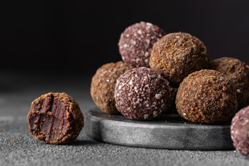 Assortment of gourmet handcrafted vegan chocolate truffle candies on dark marble background from premium confectionary. Handmade bited bonbon chocolatier concept. Horizontal banner with copy space