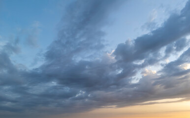 Obraz premium Dramatic clouds in a vibrant blue sky, creating a captivating sunset atmosphere. The scene evokes tranquility and change, reflecting nature's beauty.