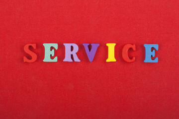 SERVICE word on red background composed from colorful abc alphabet block wooden letters, copy space for ad text. Learning english concept.