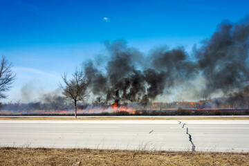 Obraz premium March marsh fire in Wisconsin: March 9 2025 in Brookfield, Wisconsin. Difficult terrain and windy conditions made fire fighting conditions difficult. Homes and businesses were threatened.