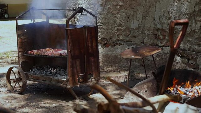 Argentinian asado grilling meat on traditional barbecue smoker. Full HD